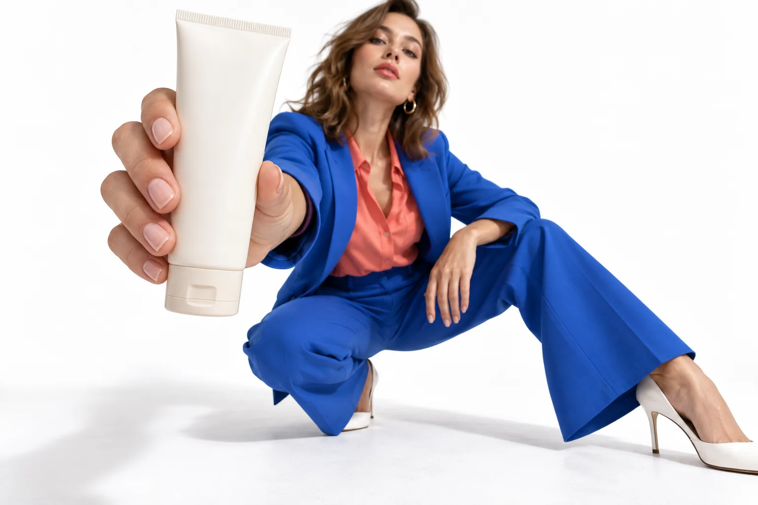 Cream cosmetic tube in the foreground with a model in blue